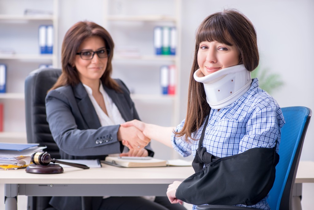 woman with neck brace consulting lawyer