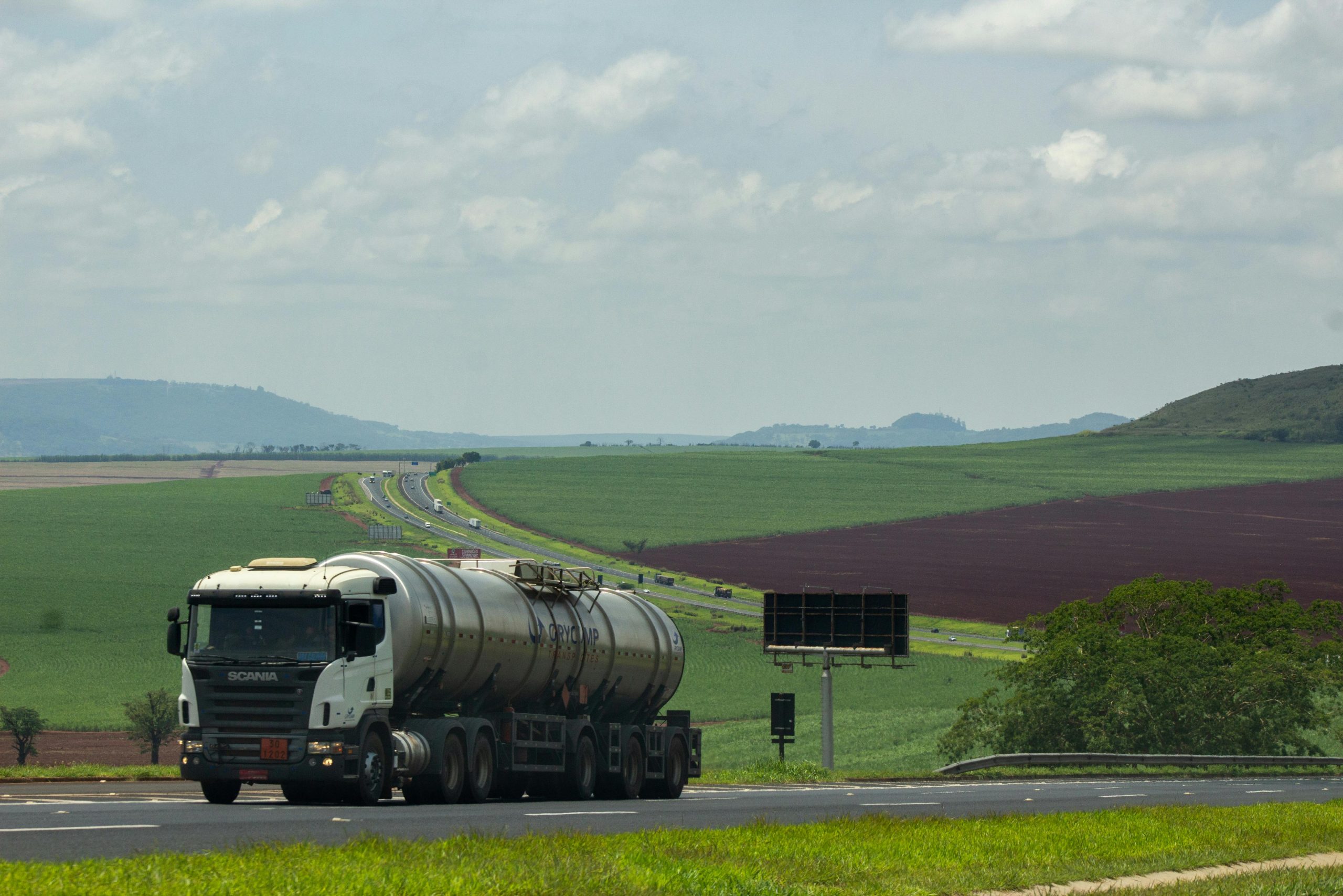 truck on a road surrounded by fields